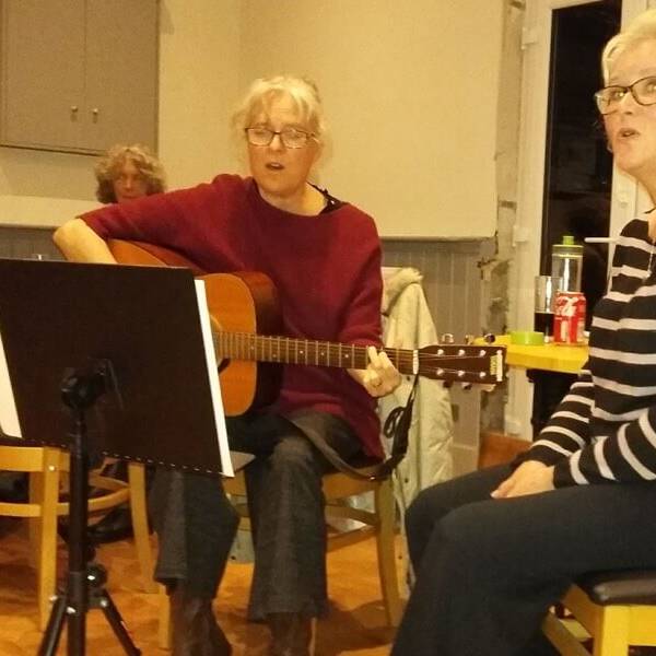 Monthly music nights - lady playing guitar and singing